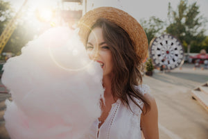 Close up portrait of a pretty young girl eating cotton candy at amusement park_edited_edit